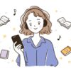 スマートフォンでオーディオブックを聴く人物とヘッドホン、本